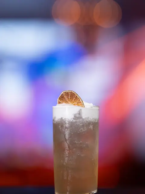 Drink longo com espuma e rodela de limão desidratada